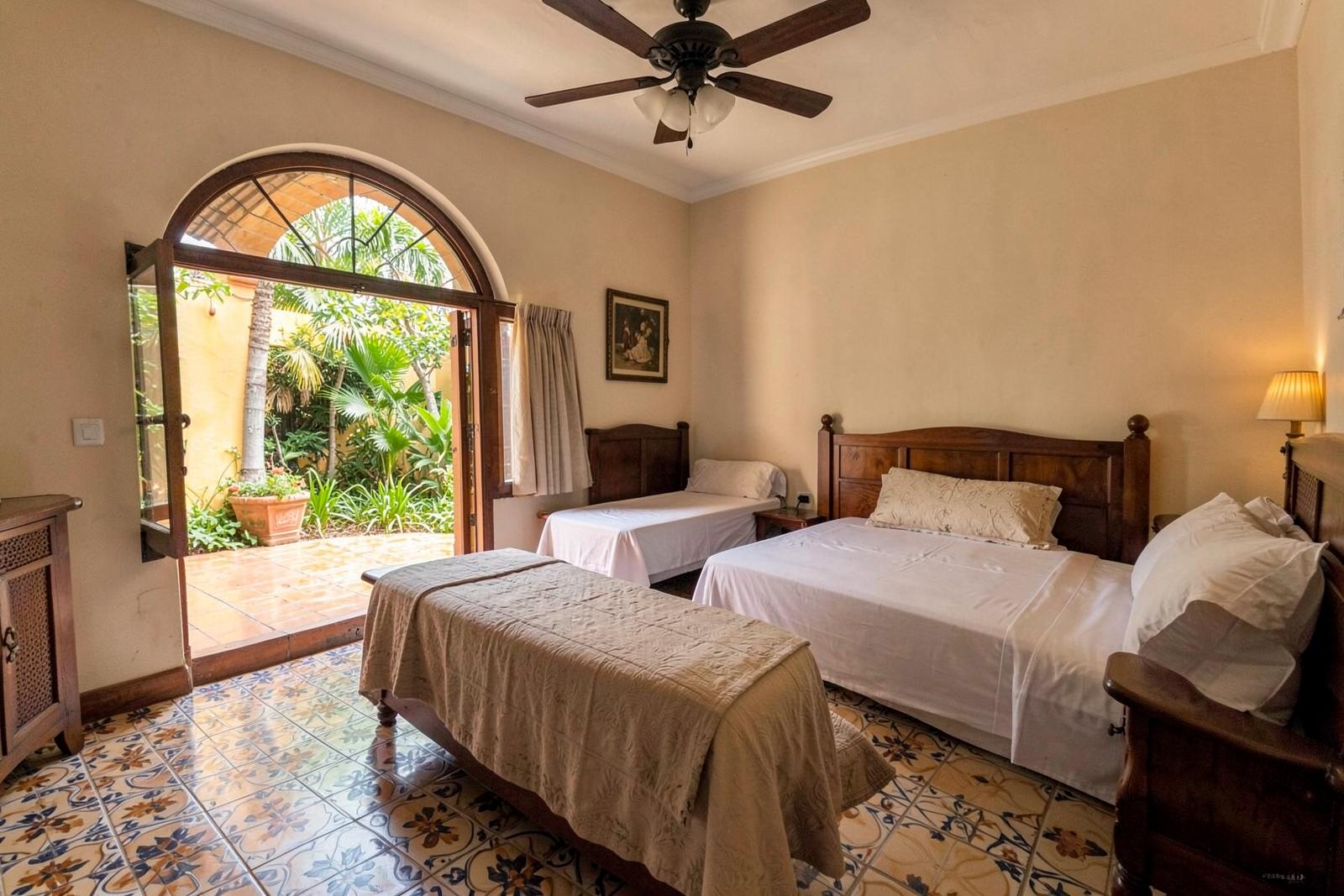 Habitación Familiar con tres camas y ventana al patio