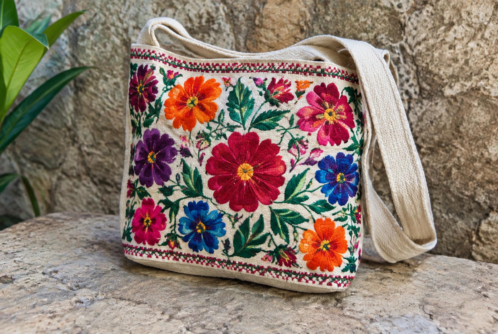 Bolso de algodón bordado a mano con flores de colores sobre piedra